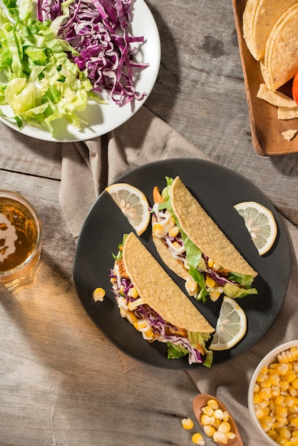 Traditioneller mexikanischer Taco mit Hühnchen und Gemüse auf Holztisch. Lateinamerikanisches Essen.