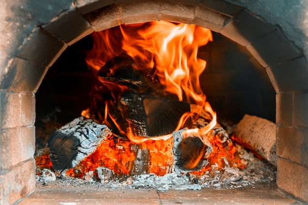 Traditioneller Pizzaofen in ein hölzernes Feuer im Restaurant