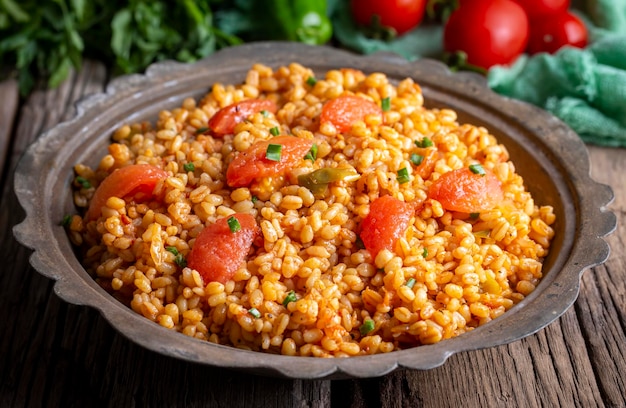 Traditioneller türkischer Bulgur-Pilaf mit Tomatensauce auf dem Teller, türkischer Name meyhane pilavi