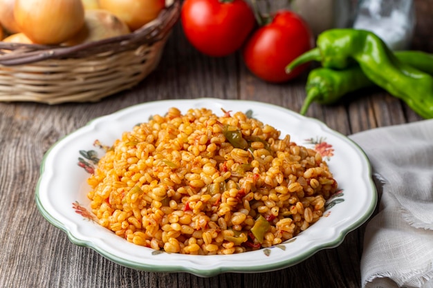 Foto traditioneller türkischer bulgur-pilaw mit tomatensoße im teller (türkischer name; meyhane pilavi)