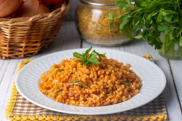 Traditioneller türkischer Bulgur-Pilaw mit Tomatensoße im Teller Türkischer Name meyhane pilavi