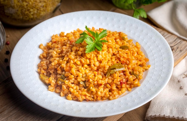 Traditioneller türkischer Bulgur-Pilaw mit Tomatensoße im Teller Türkischer Name meyhane pilavi