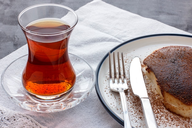 Traditioneller türkischer Nachtisch Kazandibi mit gemahlenem Zimt und türkischem Tee
