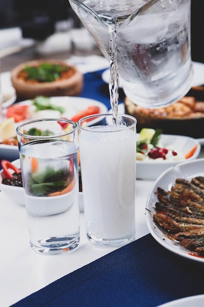 Traditioneller türkischer und griechischer Esstisch mit speziellem Alkoholgetränk Raki Ouzo und türkischem Raki i