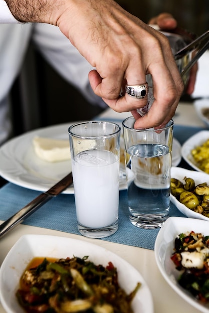 Traditioneller türkischer und griechischer Esstisch mit speziellem Alkoholgetränk Raki Ouzo und türkischem Raki