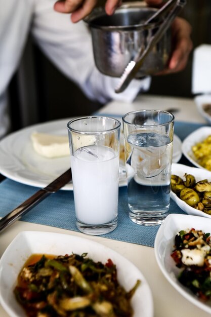 Traditioneller türkischer und griechischer Esstisch mit speziellem Alkoholgetränk Raki Ouzo und türkischem Raki