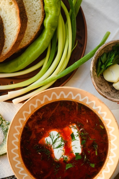 Traditioneller ukrainischer Borschtsch mit Sauerrahm in einer Tonschale