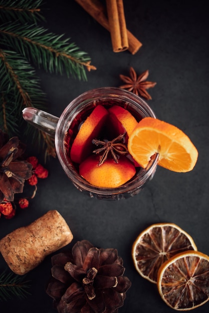 Traditioneller weihnachtlicher Glühwein. Heißgetränk mit Gewürzen in Glasschale auf dunklem Hintergrund.