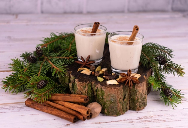 Traditioneller Weihnachts-Eierlikör auf einem Hintergrund von Tannenzweigen