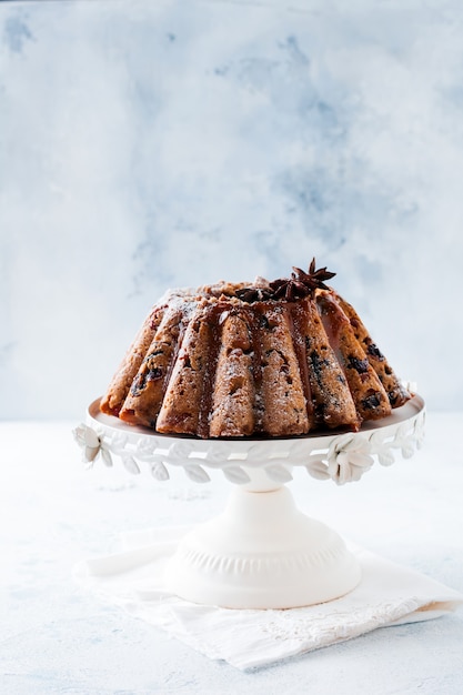 Traditioneller Weihnachtsfruchtkuchen, Pudding auf keramischem weißem Ständer