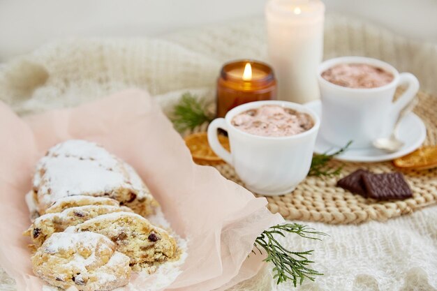 Traditioneller Weihnachtsstollen und Tassen Kaffeekerze und Winterdekorationen gemütliches Weihnachtsheim Ferienzeit süßes Dessert