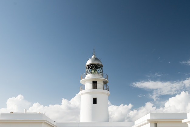 Traditioneller weißer Leuchtturm an einem sonnigen Tag in der Cap Cavallería, Menorca, Balearen, Spanien.