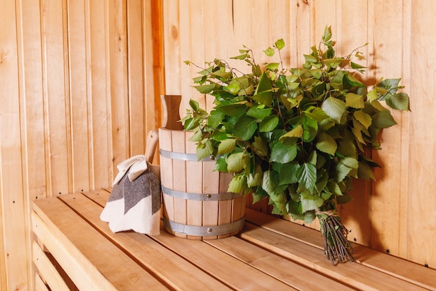 Traditionelles altes russisches Badehaus SPA-Konzept. Innendetails Finnische Sauna Dampfbad mit traditionellem Saunazubehör Becken Birkenbesenschaufel Filz. Entspannen Sie sich im Dorfbadkonzept.