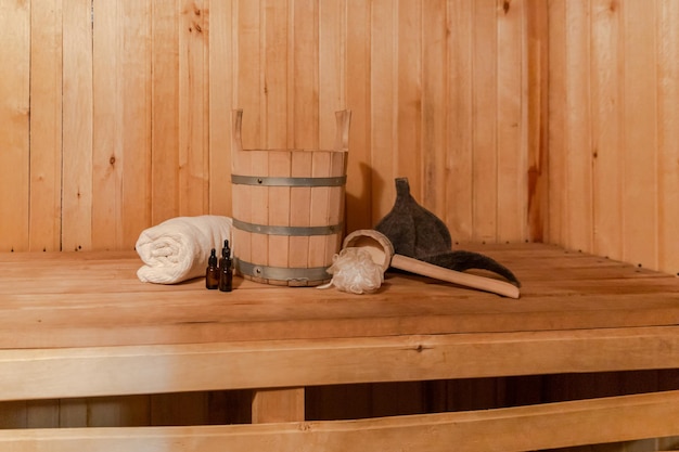 Traditionelles altes russisches Badehaus SPA-Konzept. Innendetails Finnische Sauna Dampfbad mit traditionellem Saunazubehör Set Waschbecken Handtuch Aromaöl Schaufel Filz. Entspannen Sie sich im ländlichen Dorfbad-Konzept.