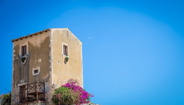 Traditionelles altes sizilianisches Haus an einem sonnigen Tag mit einem wunderschönen Hintergrund des blauen Himmels.