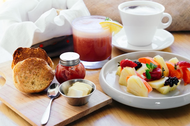 Traditionelles amerikanisches Frühstück, Saft, Kaffee, Obst und Brot auf einem Tisch.