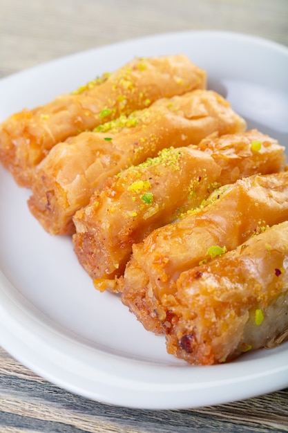 Traditionelles arabisches Nachtischbaklava mit Acajoubaum, Walnüssen und Kardamom mit einer Eukalyptusniederlassung auf einem Holztisch