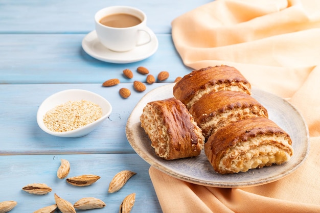 Traditionelles armenisches Dessert Gata mit Tasse Kaffee auf blauem Holzhintergrund, Seitenansicht aus nächster Nähe