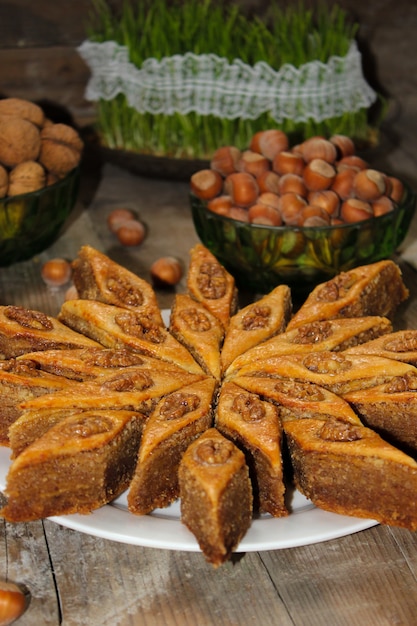 Traditionelles Aserbaidschan-Feiertagsplätzchenbaklava auf weißer Platte auf dem rustikalen mit Nüssen