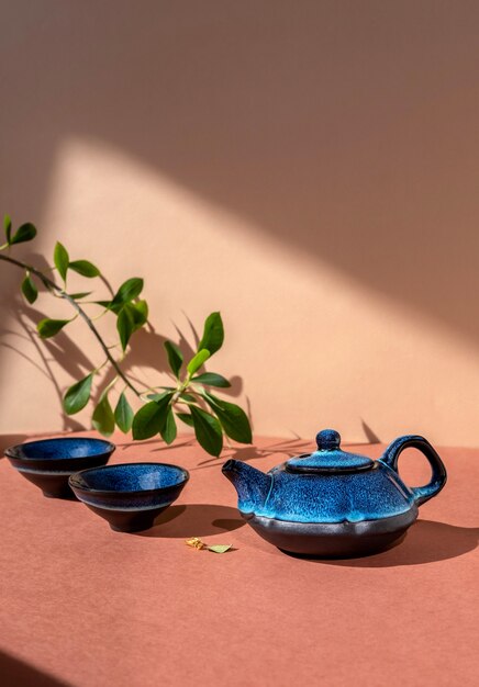 Traditionelles asiatisches Teezeremoniekonzept. Blaue Teekanne und Teetassen auf brauner Wand.