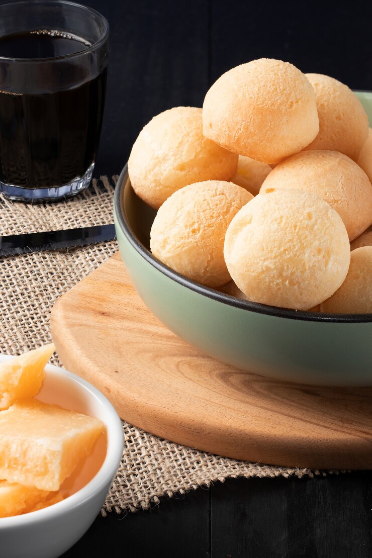 Traditionelles brasilianisches Käsebrot (pão de queijo) in einer grünen Schüssel.