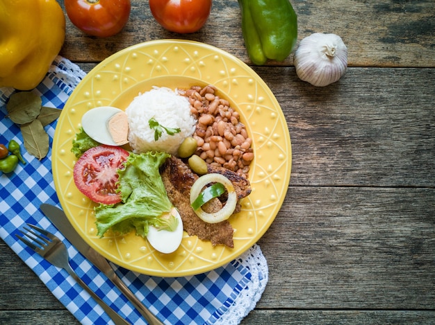 Traditionelles brasilianisches Speisegericht Bohnen Reisfleisch und Salat Draufsicht.