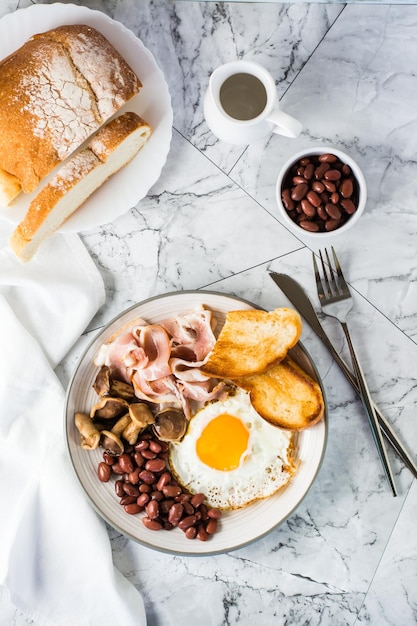 Traditionelles englisches Frühstück mit Eierspeck, Bohnen, Pilzen und Toast Draufsicht und vertikale Ansicht