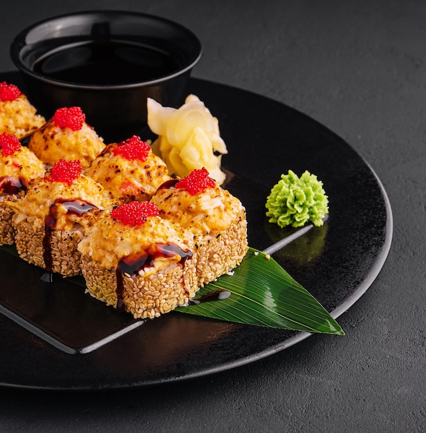 Traditionelles gebackenes japanisches Sushi auf schwarzer Platte