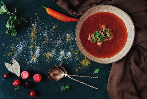 Traditionelles georgisches Gericht würzige Tomaten-Kharcho-Suppe auf dunklem Hintergrund, keine Draufsicht der Menschen