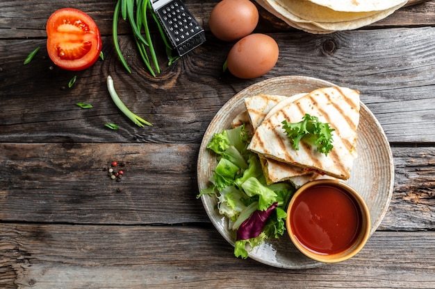 Traditionelles Gericht Quesadilla der mexikanischen Küche mit Rührei, Gemüse, Schinken und Käse