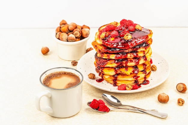 Traditionelles hausgemachtes Frühstück mit Pfannkuchen und Kaffee Himbeer-Haselnuss-Süßmarmelade
