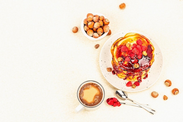 Traditionelles hausgemachtes Frühstück mit Pfannkuchen und Kaffee Himbeer-Haselnuss-Süßmarmelade