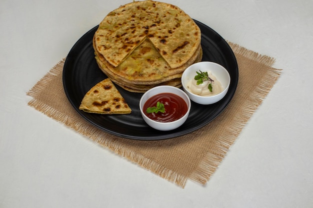 Traditionelles indisches Essen Aloo Paratha oder mit Kartoffeln gefülltes Fladenbrot. serviert mit Tomatenketchup