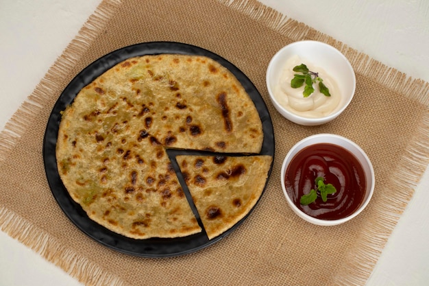 Traditionelles indisches Essen Aloo Paratha oder mit Kartoffeln gefülltes Fladenbrot. serviert mit Tomatenketchup