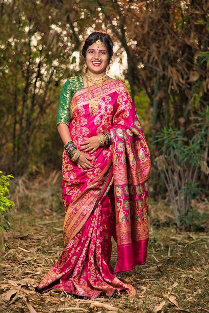 Foto traditionelles indisches schönes junges mädchen in sari, das im freien im park posiert