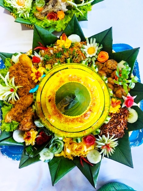 Foto traditionelles indonesisches tumpeng-essen aus gelbem reis mit gebratenem huhn dekoriert