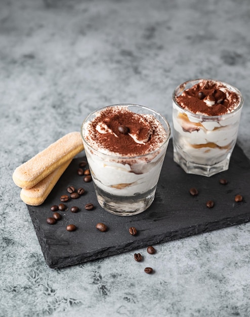 Traditionelles italienisches Dessert Tiramisu Portionsdessert aus Savoiardi und Mascarpone mit Kakao