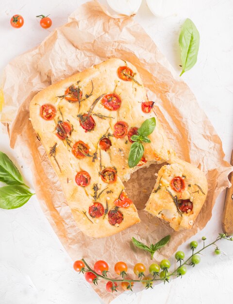 Traditionelles italienisches Focaccia-Brot mit Tomaten und Rosmarin im mentalen Backblech