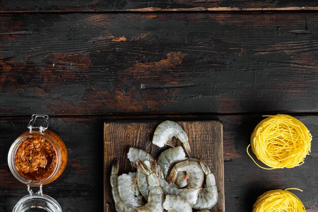 Traditionelles italienisches Gericht. Pasta mit Pesto-Ricotta-Parmesan und gegrillten Meeresfrüchte-Zutaten auf altem dunklem Holztisch, Draufsicht flach, mit Kopierraum für Text