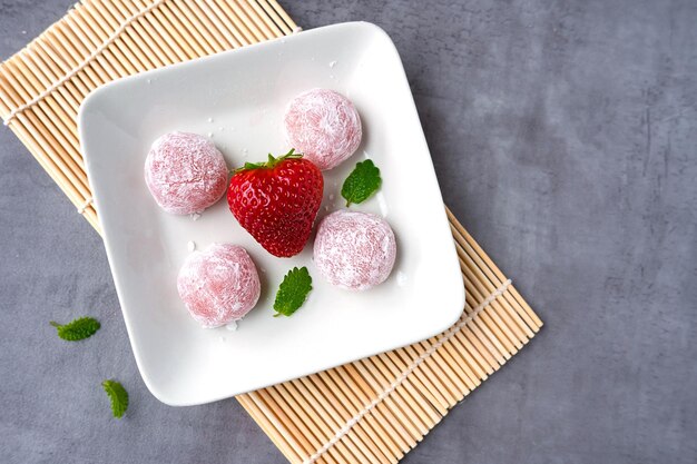 Traditionelles japanisches Dessert, Erdbeer-Mochi auf einem Teller, Reis, asiatische Süßigkeiten