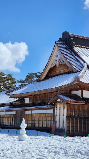 Foto traditionelles japanisches gebäude mit schneebedecktem dach und schneemann davor in hakodate, japan