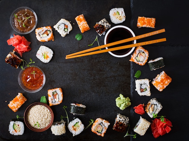 Traditionelles japanisches Lebensmittel - Sushi, Rollen und Soße auf einem dunklen Hintergrund. Ansicht von oben