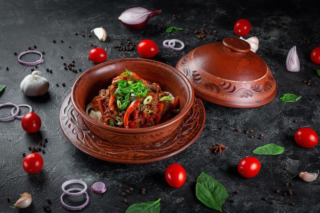 Traditionelles kasachisches Gericht Kuirdak Aromatischer Lammbraten aus Nebenprodukten mit viel Zwiebeln und Gemüse im Tontopf