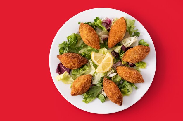 Traditionelles libanesisches Kibbeh mit Zitrone auf weißem Teller