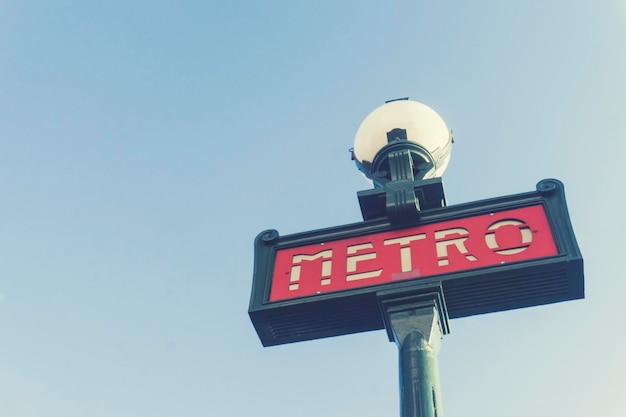 Traditionelles Pariser U-Bahn-Schild vor einem strahlend blauen Himmel