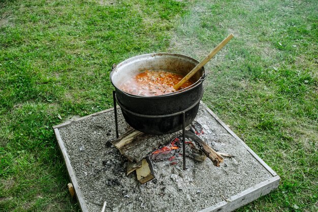 Foto traditionelles rumänisches essen, das im kessel am offenen feuer zubereitet wird