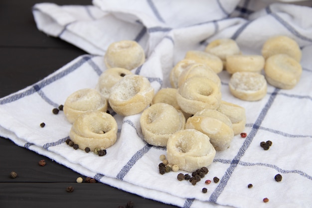 Traditionelles russisches pelmeni auf rustikalem Holztisch. Hausgemachte Knödel. Halbfertige Produkte.