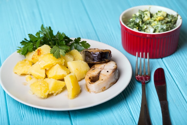 Traditionelles skandinavisches Abendessen - Salzkartoffeln und Makrele auf blauem Hintergrund