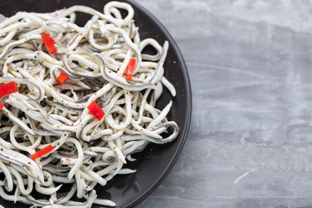 Traditionelles spanisches Essen. Gulas mit Öl auf weißem Teller.