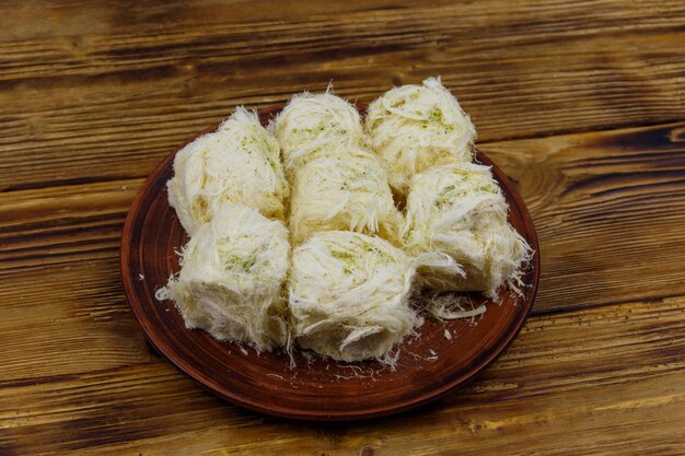 Traditionelles türkisches Dessert Pismaniye mit Pistazien auf Holztisch